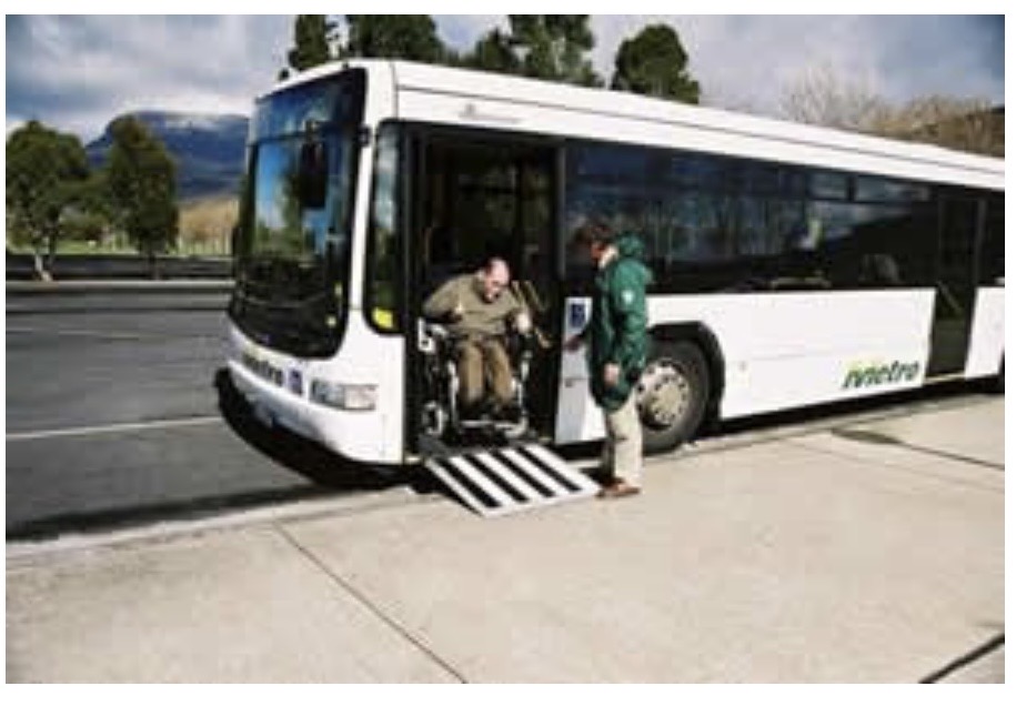 Wheelchair ramp deployed on bus — driver assisting wheelchair user